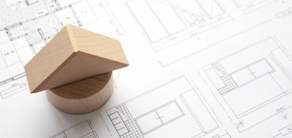Hausmodell aus Holz auf Bauplänen
