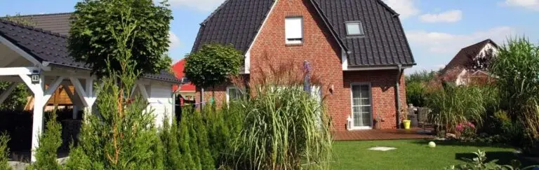 Einfamilienhaus mit roter Klinkerfassade und Garten