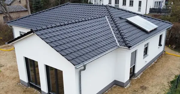 Neubau mit weißer Fassade und Photovoltaikanlage auf dem Dach
