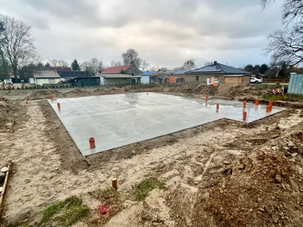 Fertige Bodenplatte auf dem Baugrundstück nach Regen