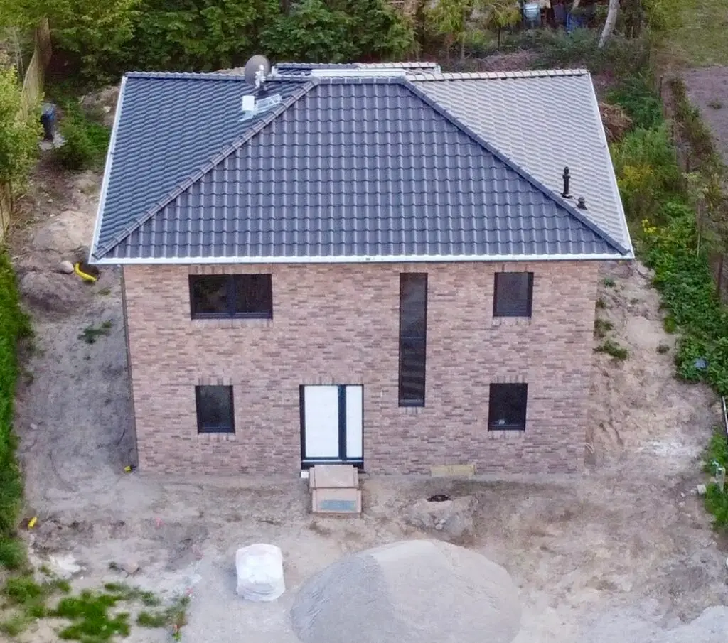 Luftaufnahme eines Rohbaus mit fertig gedecktem Dach