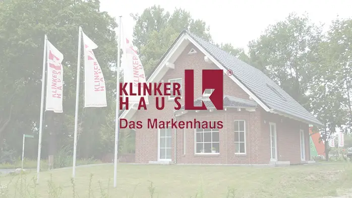 Klinker-Einfamilienhaus mit Satteldach und KLINKER HAUS Fahnen davor, überlagert mit dem Markenlogo